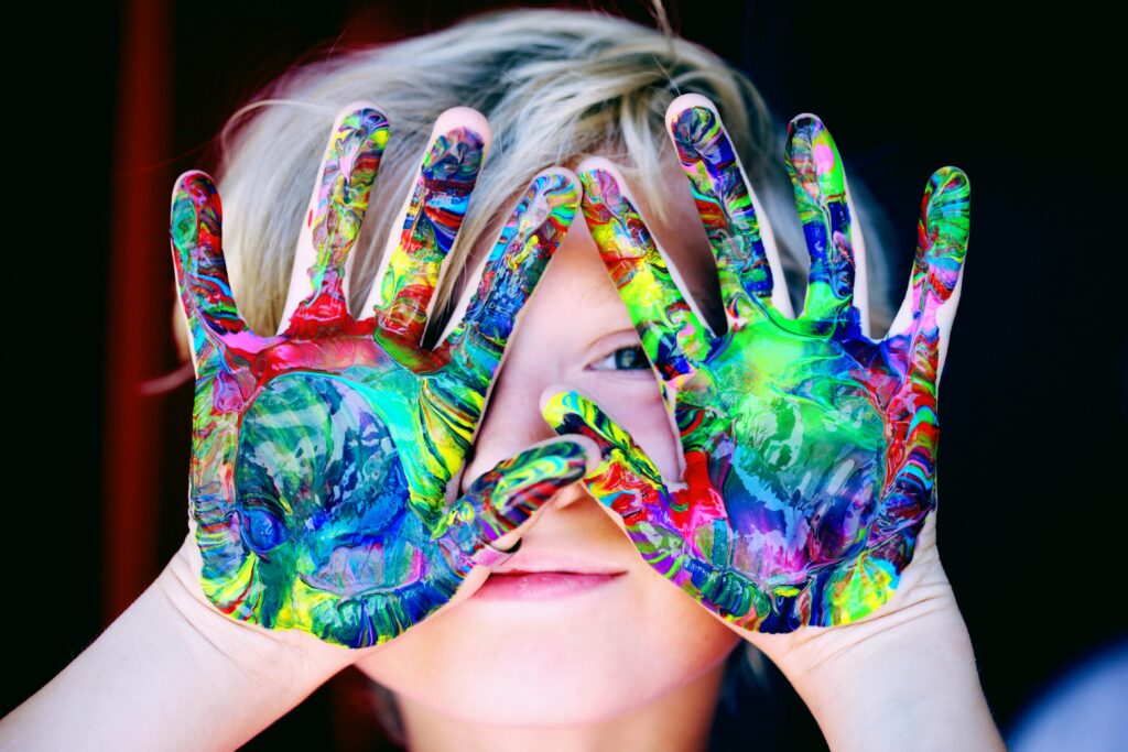 an autistic child with monotropic tendencies show paint on his hands